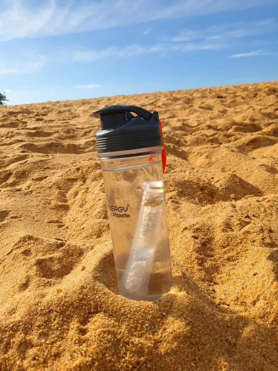 Squeeze Alcaline MAX na areia da praia, cheia de água